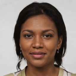 Joyful black young-adult female with medium  brown hair and brown eyes