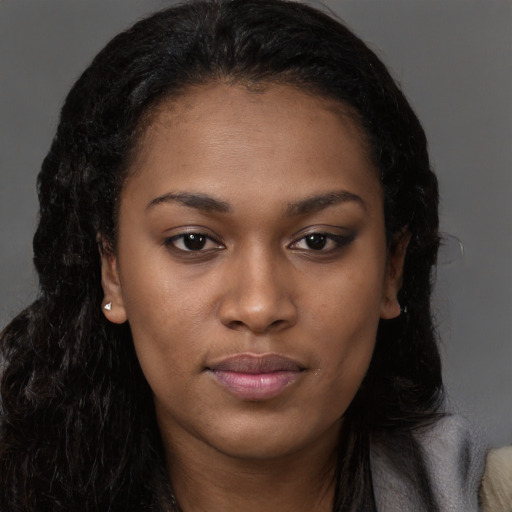 Joyful black young-adult female with long  brown hair and brown eyes