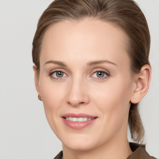 Joyful white young-adult female with long  brown hair and grey eyes