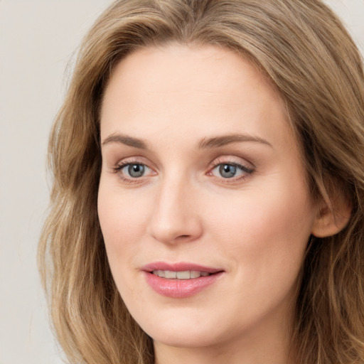 Joyful white young-adult female with long  brown hair and green eyes