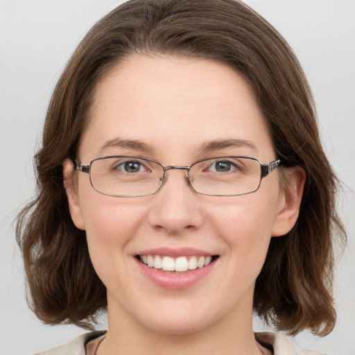 Joyful white young-adult female with medium  brown hair and grey eyes