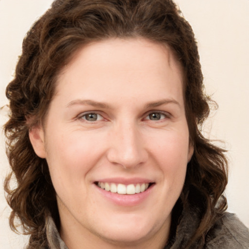 Joyful white young-adult female with long  brown hair and green eyes