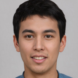 Joyful asian young-adult male with short  brown hair and brown eyes