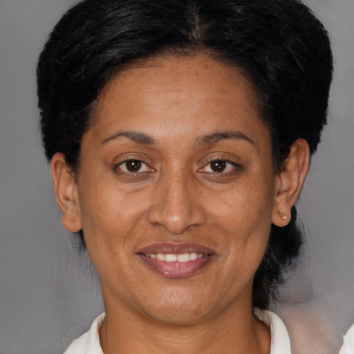Joyful black adult female with short  brown hair and brown eyes