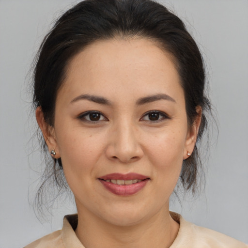 Joyful asian adult female with medium  brown hair and brown eyes
