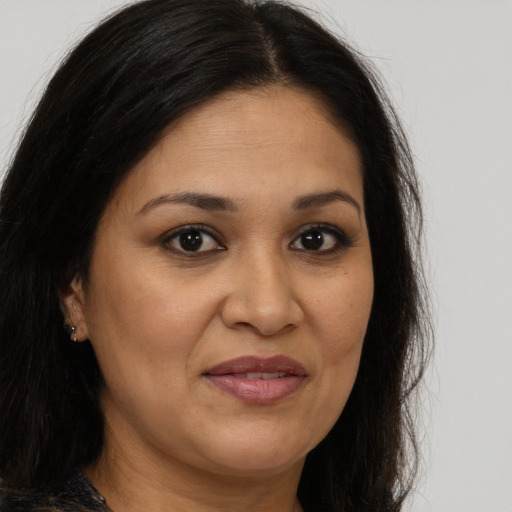 Joyful latino adult female with long  brown hair and brown eyes