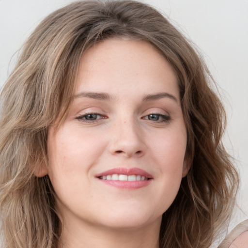 Joyful white young-adult female with long  brown hair and blue eyes