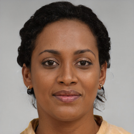 Joyful black adult female with short  brown hair and brown eyes