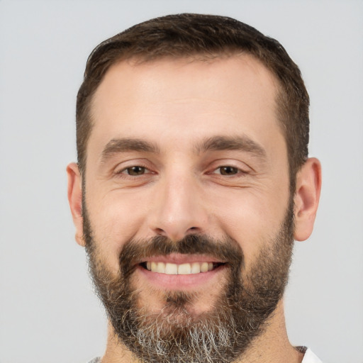 Joyful white young-adult male with short  brown hair and brown eyes