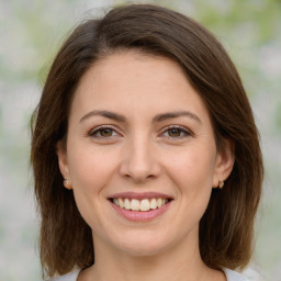 Joyful white young-adult female with medium  brown hair and green eyes