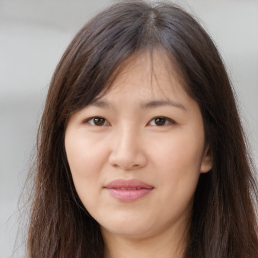 Joyful asian young-adult female with long  brown hair and brown eyes