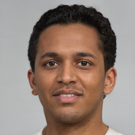 Joyful black young-adult male with short  brown hair and brown eyes