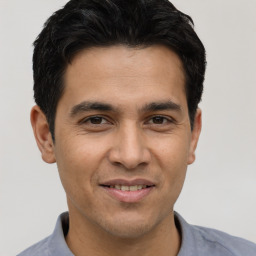 Joyful white young-adult male with short  black hair and brown eyes