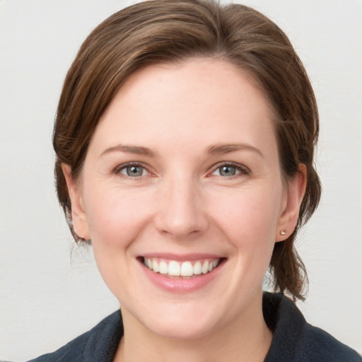 Joyful white young-adult female with medium  brown hair and blue eyes