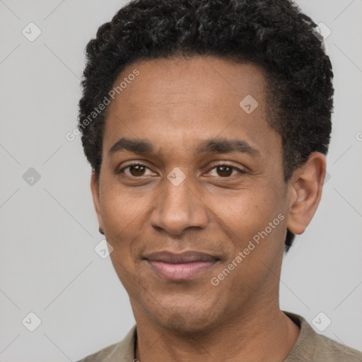 Joyful black adult male with short  black hair and brown eyes