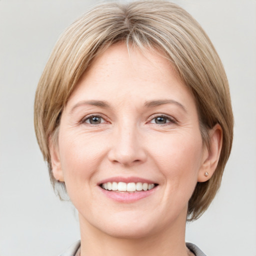 Joyful white adult female with medium  brown hair and grey eyes