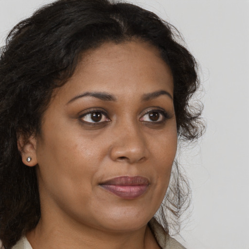 Joyful black adult female with long  brown hair and brown eyes