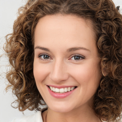 Joyful white young-adult female with medium  brown hair and green eyes