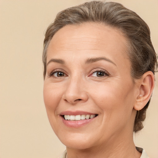 Joyful white adult female with medium  brown hair and brown eyes