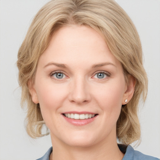 Joyful white young-adult female with medium  brown hair and blue eyes