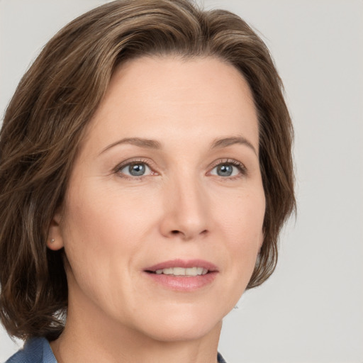 Joyful white adult female with medium  brown hair and grey eyes