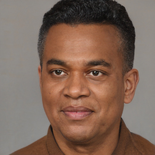 Joyful black young-adult male with short  black hair and brown eyes