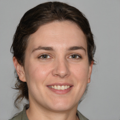 Joyful white young-adult female with medium  brown hair and grey eyes