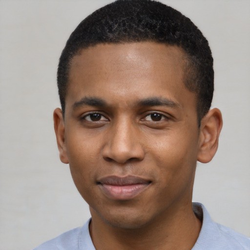 Joyful black young-adult male with short  black hair and brown eyes