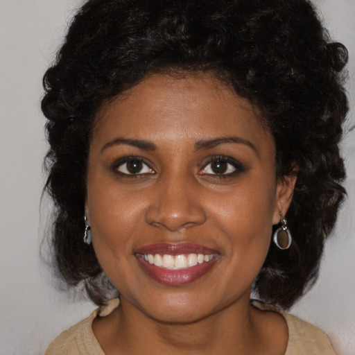 Joyful black young-adult female with long  brown hair and brown eyes