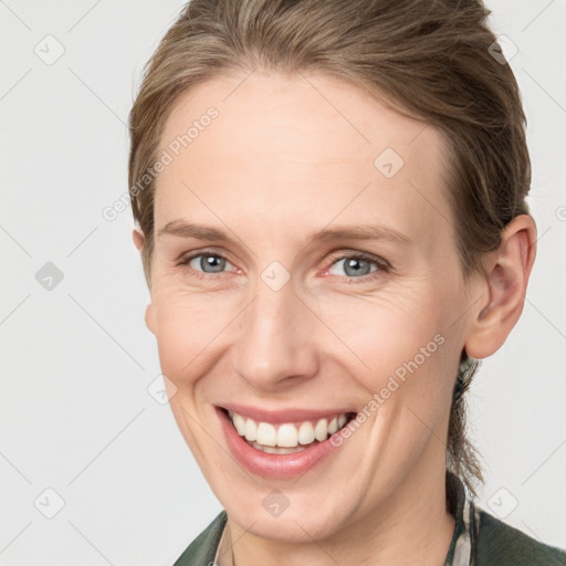 Joyful white adult female with medium  brown hair and grey eyes