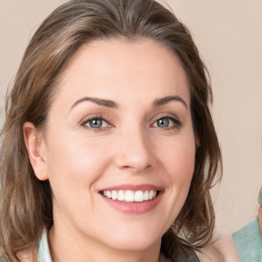 Joyful white young-adult female with medium  brown hair and green eyes