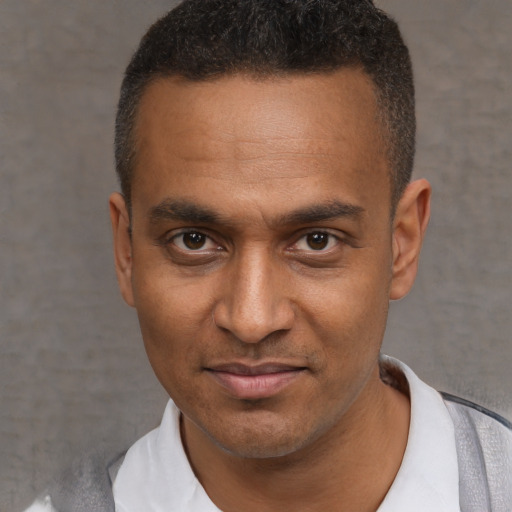 Joyful black young-adult male with short  black hair and brown eyes