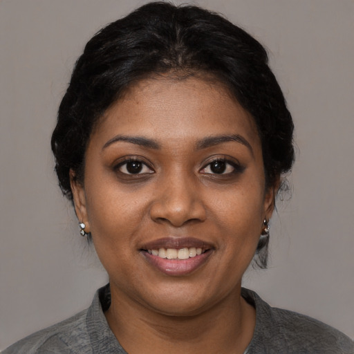 Joyful black young-adult female with short  black hair and brown eyes