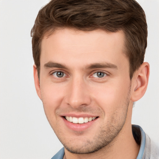 Joyful white young-adult male with short  brown hair and grey eyes