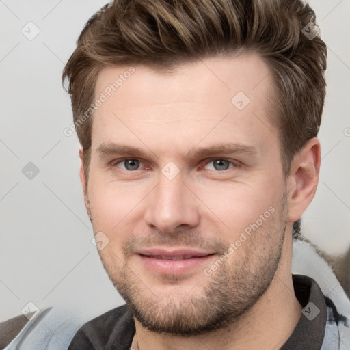 Joyful white young-adult male with short  brown hair and grey eyes