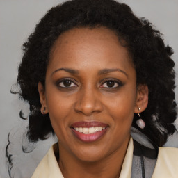 Joyful black adult female with medium  brown hair and brown eyes