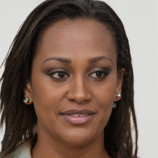 Joyful black young-adult female with long  brown hair and brown eyes