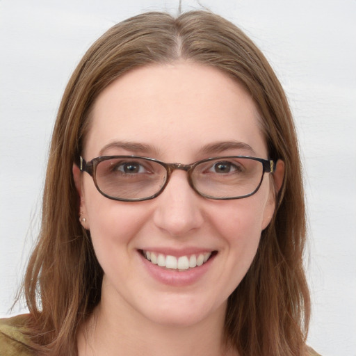 Joyful white young-adult female with long  brown hair and blue eyes