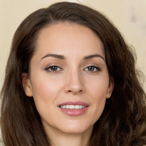 Joyful white young-adult female with long  brown hair and brown eyes