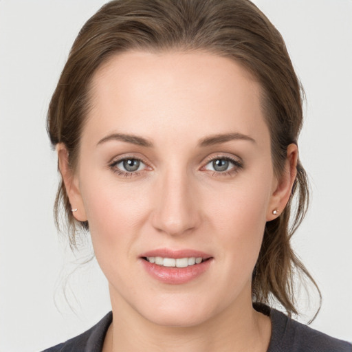 Joyful white young-adult female with medium  brown hair and grey eyes