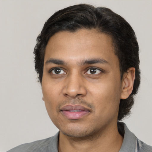 Joyful latino young-adult male with short  black hair and brown eyes