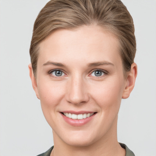 Joyful white young-adult female with short  brown hair and grey eyes