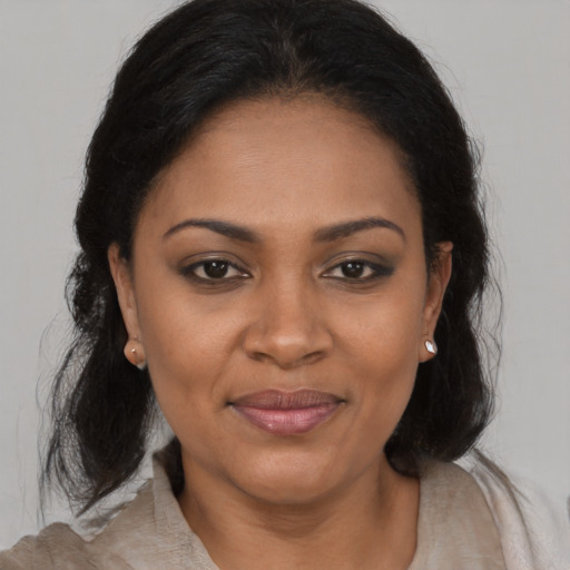 Joyful black adult female with medium  brown hair and brown eyes