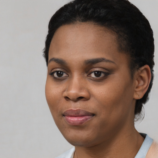 Joyful black young-adult female with short  black hair and brown eyes