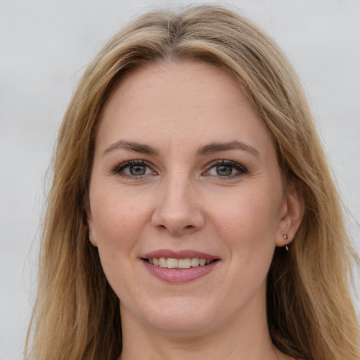 Joyful white young-adult female with long  brown hair and green eyes