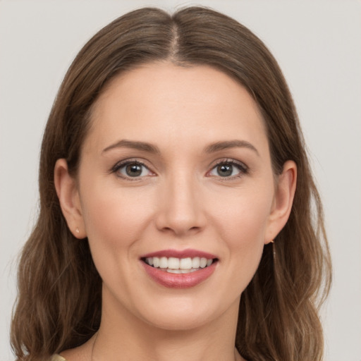 Joyful white young-adult female with long  brown hair and grey eyes