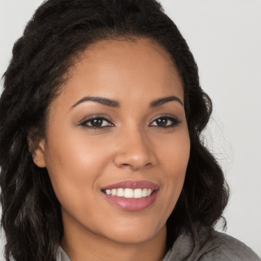 Joyful latino young-adult female with long  brown hair and brown eyes