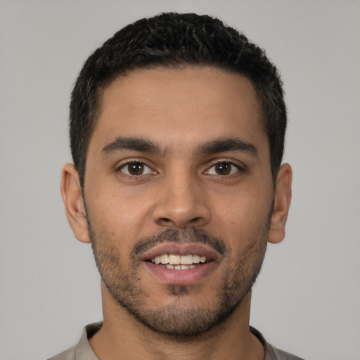 Joyful latino young-adult male with short  brown hair and brown eyes