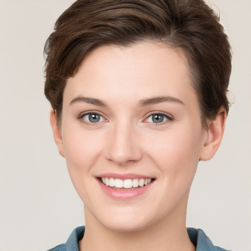 Joyful white young-adult female with short  brown hair and grey eyes