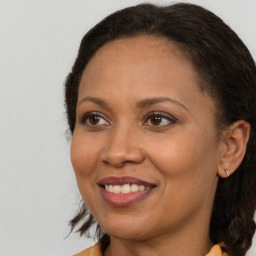 Joyful black adult female with long  brown hair and brown eyes